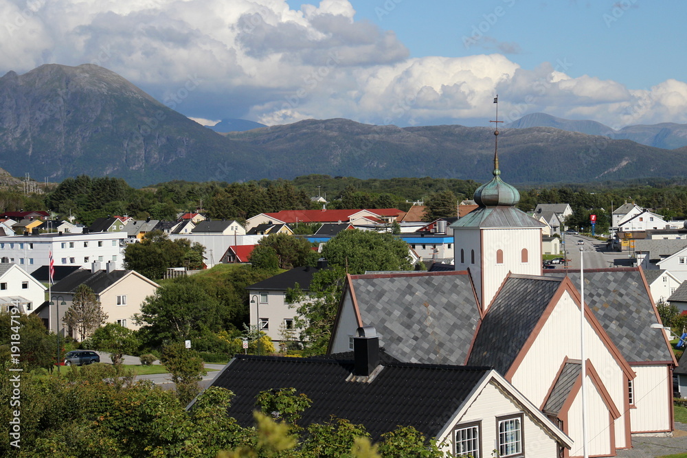 typische Häuser und Kirche in Norwegen vor den Bergen in Molde