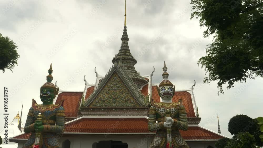 close up of two gigantic demon statues at wat arun temple in bangkok, thailand close up of two gigantic demon statues at wat arun temple in bangkok, thailand