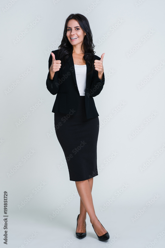 Everything is perfect. Full Length of beautiful young businesswoman looking at camera and gesturing thumb up with smile while standing against white background