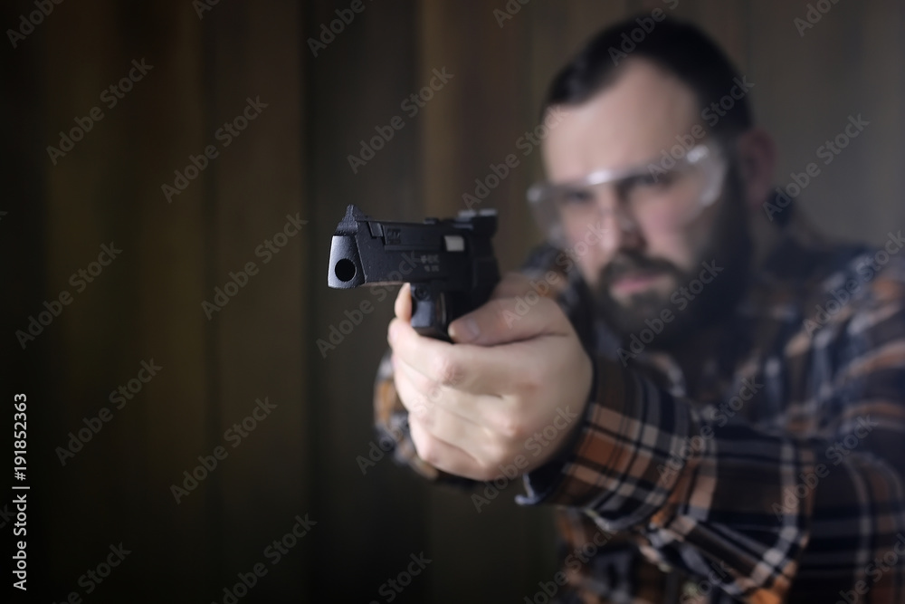 man with put on protective goggles and ear training in pistol sh man with put on protective goggles and ear training in pistol sh