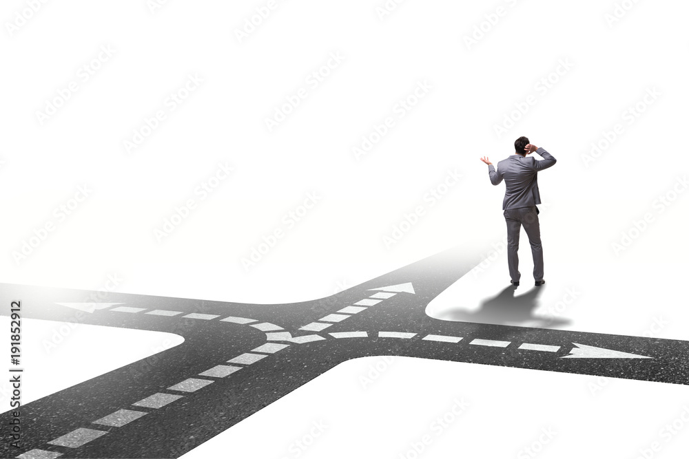 Fototapeta premium Young businessman at crossroads in uncertainty concept