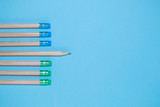 Flat lay of 7 pencils on blue background