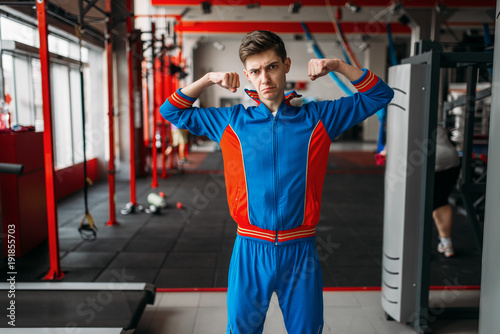 Cuadro en lienzo Skinny man in sportswear shows his muscles, gym