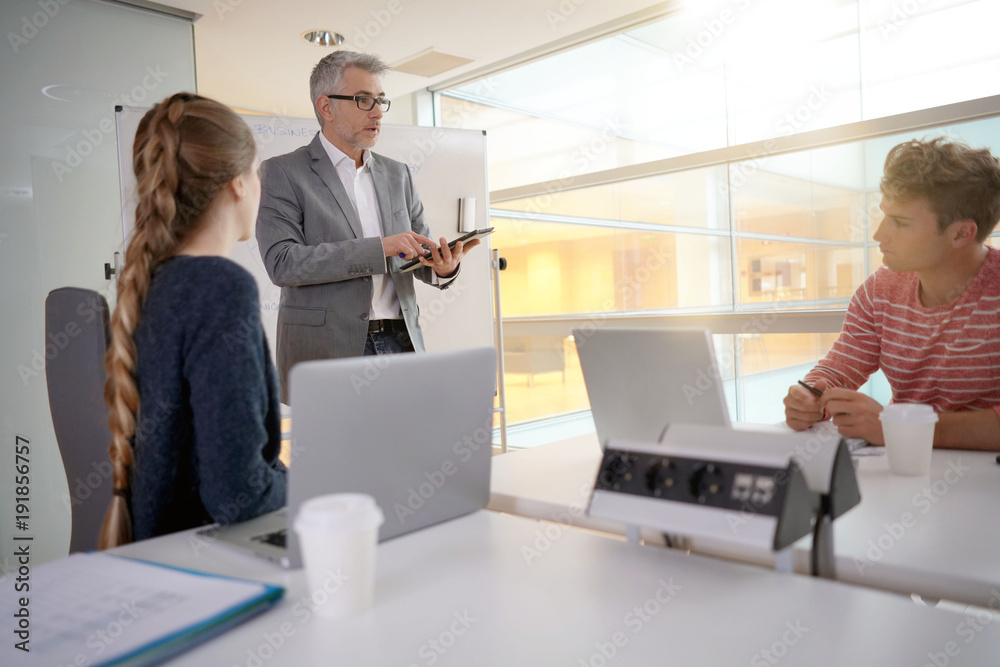 Economics teacher giving business class to students