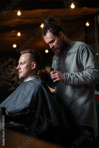 Barber cutting hair of customer. Small business