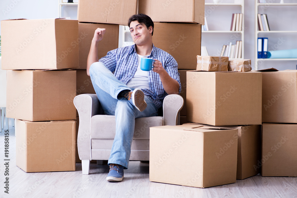 Young man moving in to new house with boxes Young man moving in to new house with boxes