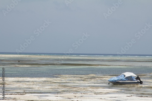 Zanzibar (Tanzania) beach during low tide with a speed boat