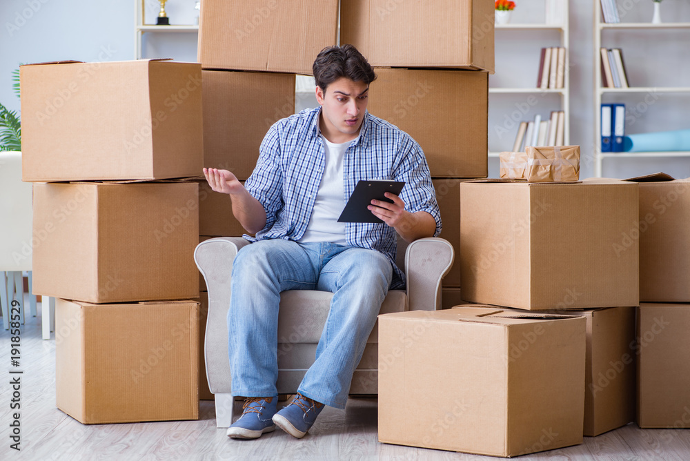Young man moving in to new house with boxes Young man moving in to new house with boxes