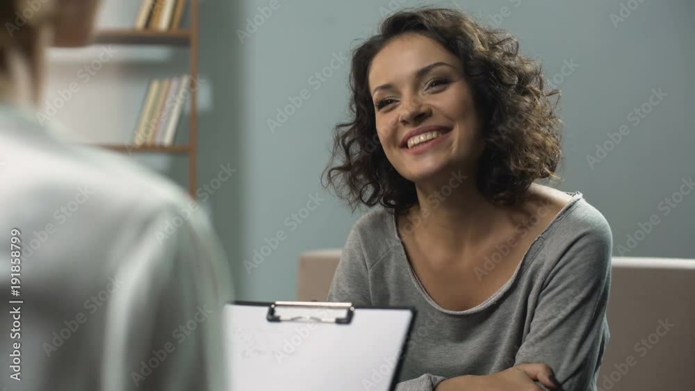 Last session of rehab therapy, smiling woman talking with psychologist at clinic