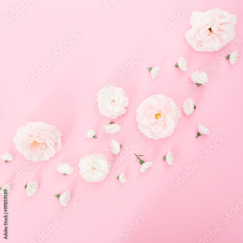 White roses flowers arrangement on pink background. Flat lay, top view. Pastel background.