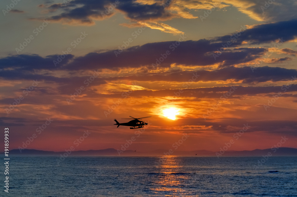 Sonnenuntergang mit Helicopter über See