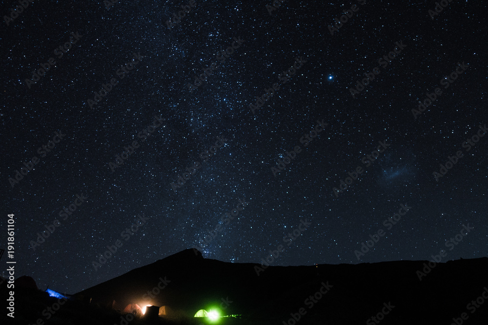 sky full of the stars above the glowing camping area of the rinjani, indonesia sky full of the stars above the glowing camping area of the rinjani, indonesia