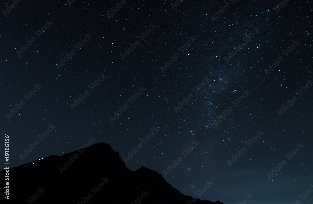 people is climbing the mountain peak in the dark night with the sky full of the stars at Rinjani