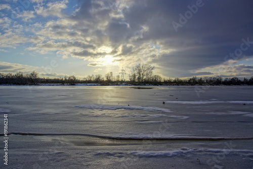 colorful winter sunset on frozen river ice