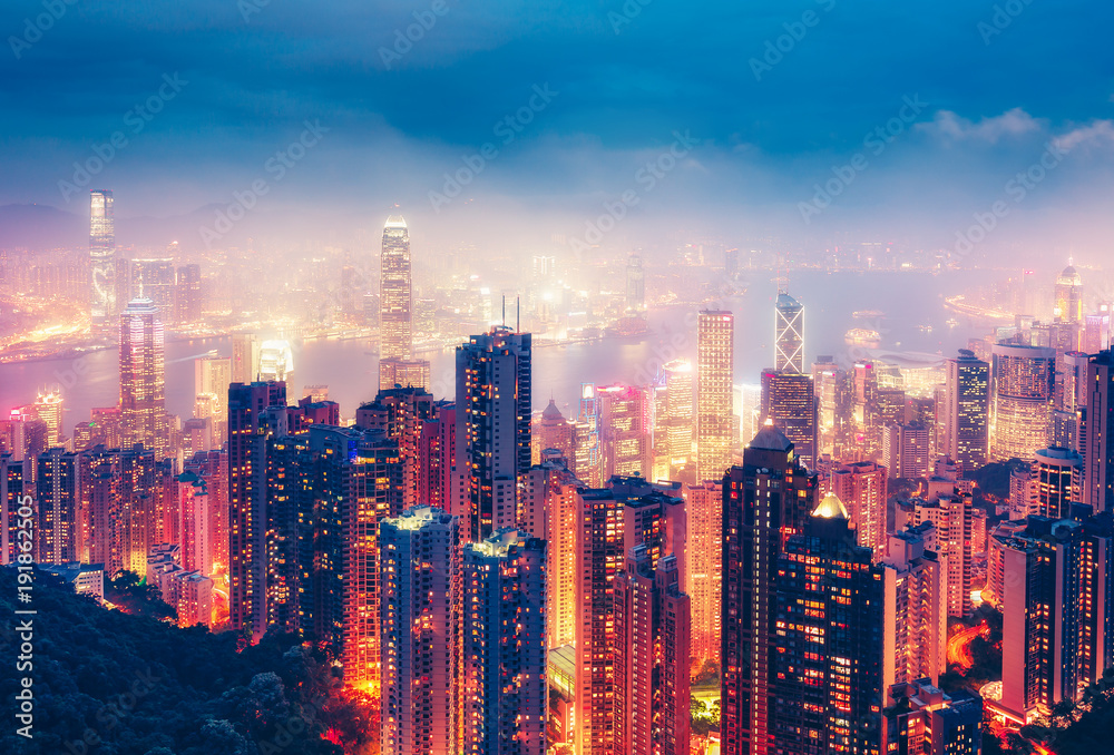 Scenic view over Hong Kong island, China, by night. Multicolored nighttime skyline with illuminated skyscrapers seen from Victoria Peak