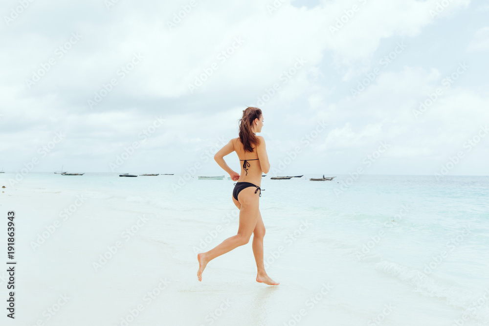 Young woman runs into ocean. Summer background Young woman runs into ocean. Summer background