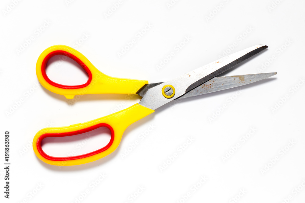 Metal scissors with yellow and red plastic holder on white background Metal scissors with yellow and red plastic holder on white background