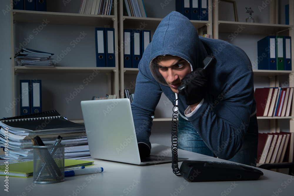 Young hacker hacking into computer at night Young hacker hacking into computer at night