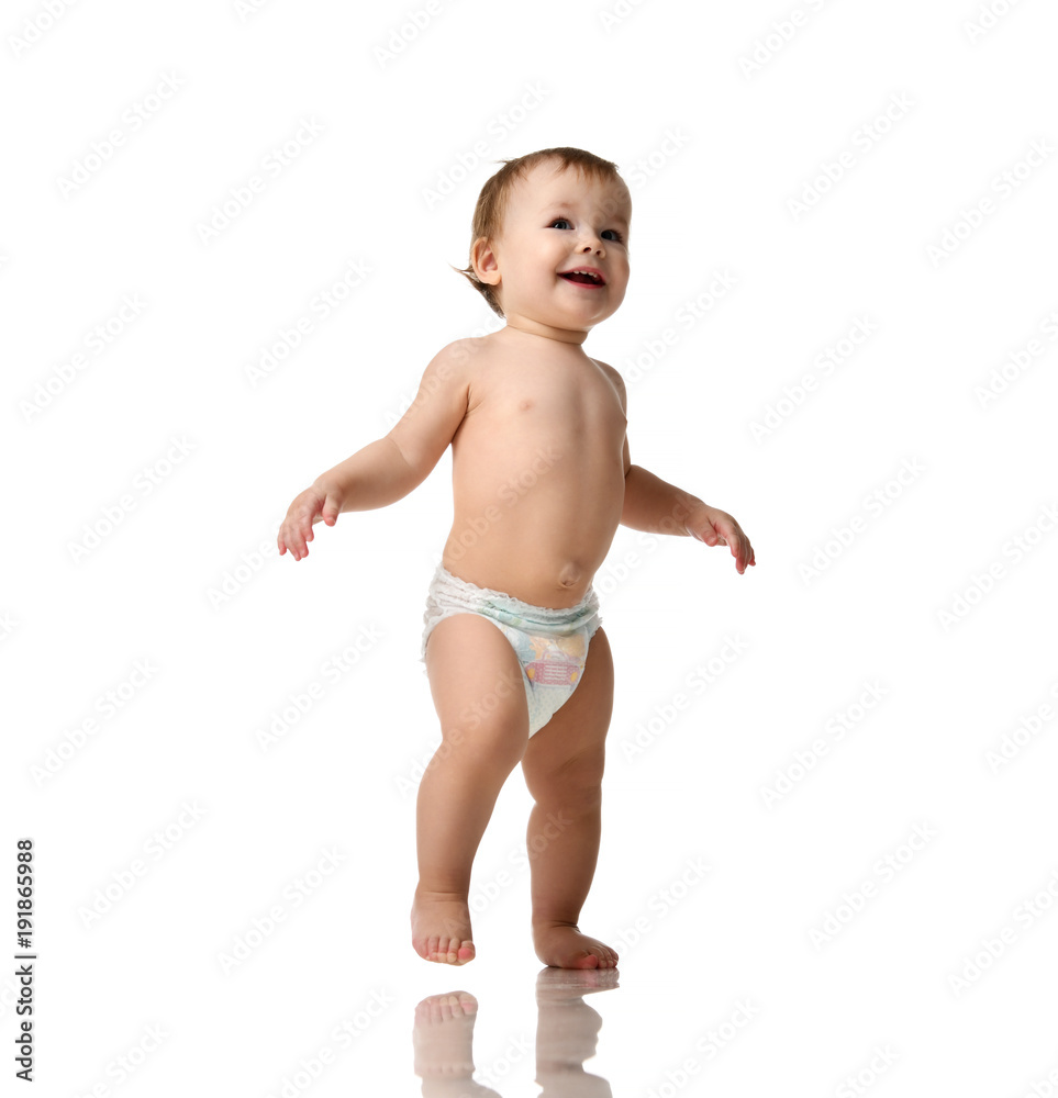 Infant child baby girl kid toddler in diaper make first steps Infant child baby girl kid toddler in diaper make first steps