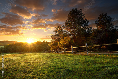 Picturesque landscape, fenced ranch at sunrise photo