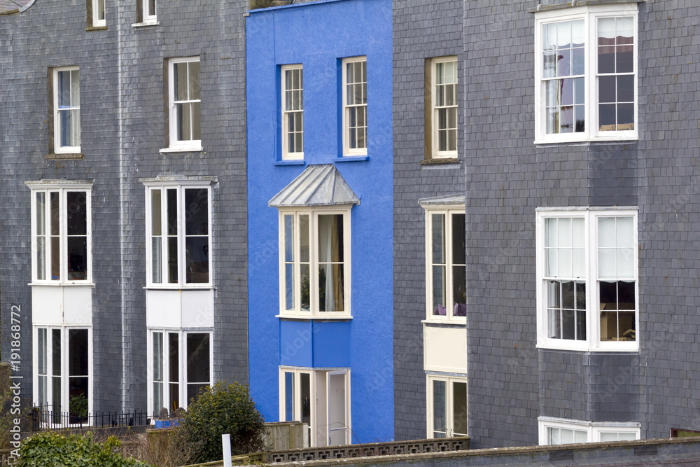 A vibrant blue painted house amongst grey slate at Tenby, Pembrokeshire, Wales, UK