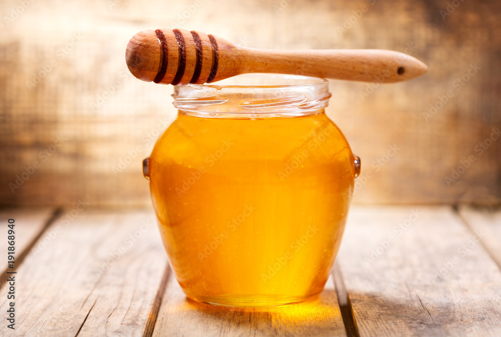 jar of honey on wooden table jar of honey on wooden table