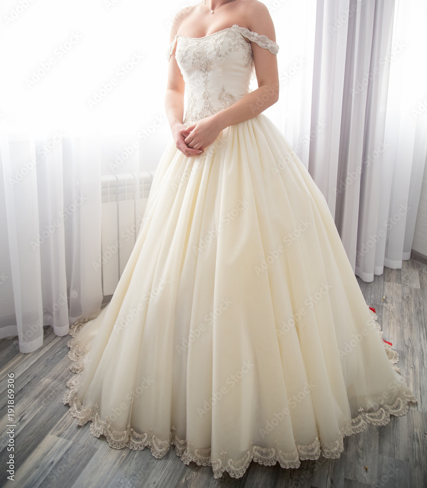 Fototapeta premium The bride stands near the window