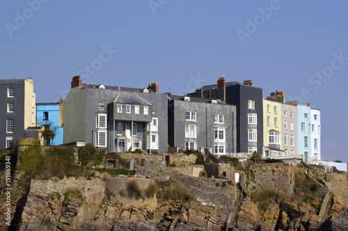 UK, Wales, Pembrokeshire, Tenby, a vibrant blue painted house stands out amongst the grey houses on the cliff tops