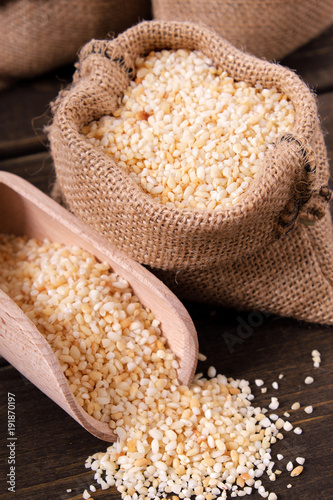 Scoop of rice on wooden table background