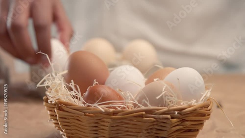 man takes eggs from the basket and put it to the baxoes. Small farmm worker photo