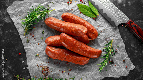 Freshly made raw breed butchers sausages in skins with herbs on crumpled paper. photo