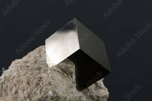 Photos Shiny smooth regular shape pyrite cube on a dark background