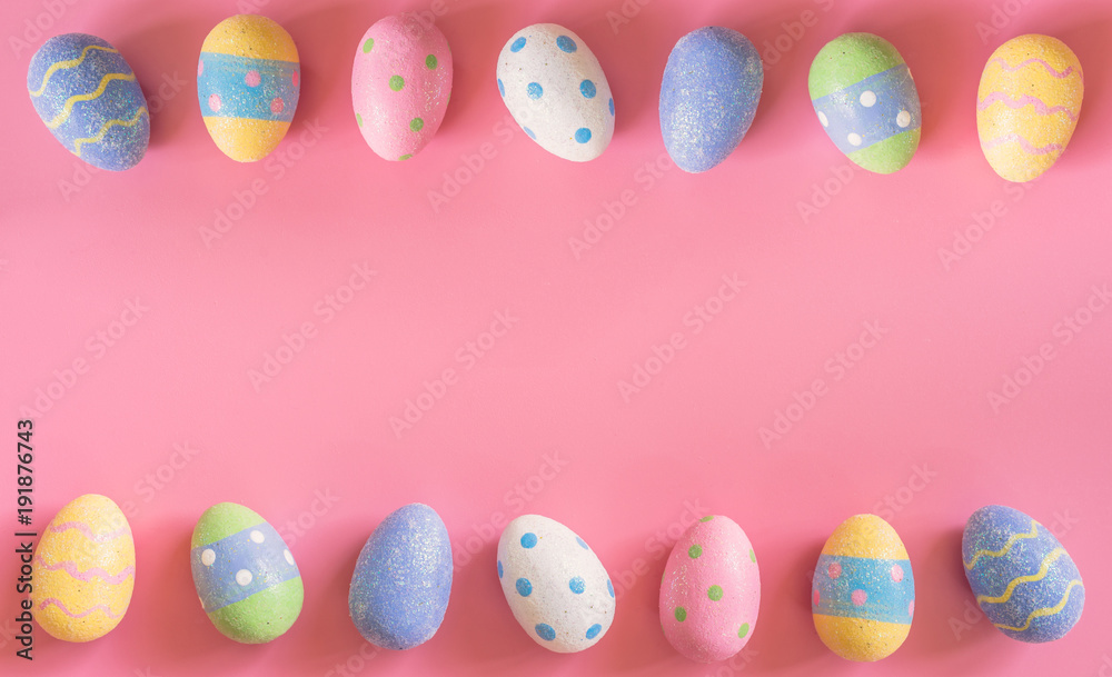 Colorful easter eggs on pink pastel color background with space.