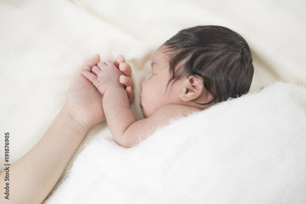 Parents and sisters holding hands baby hand in the bedroom. Parents and sisters holding hands baby hand in the bedroom.