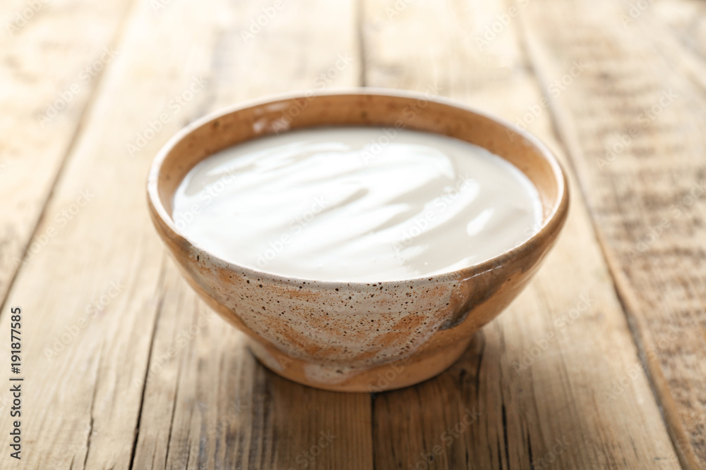 Tasty yogurt in dish on wooden table Tasty yogurt in dish on wooden table