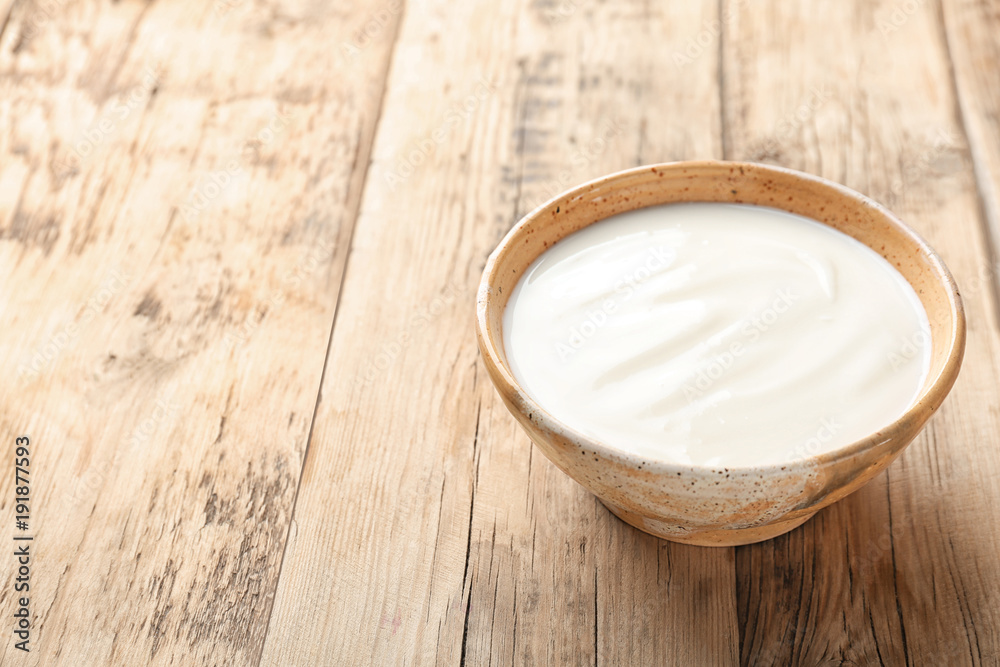 Tasty yogurt in dish on wooden table Tasty yogurt in dish on wooden table
