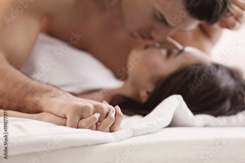 Sexy young lovers being intimate in bed, closeup