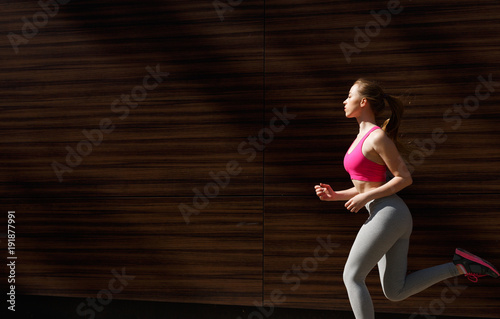 Young woman running in city copy space