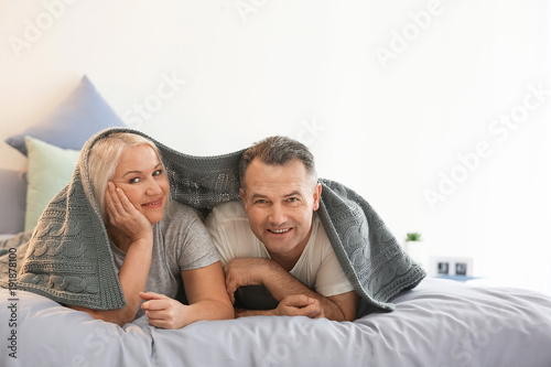 Senior couple under plaid o...