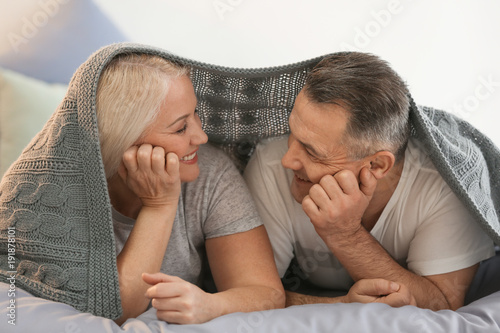 Senior couple under plaid o...