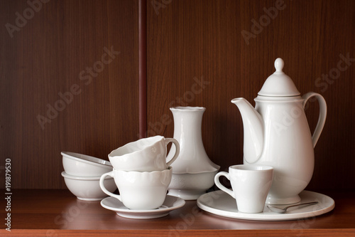     White porcelain tableware for coffee  located on a shelf in the closet.