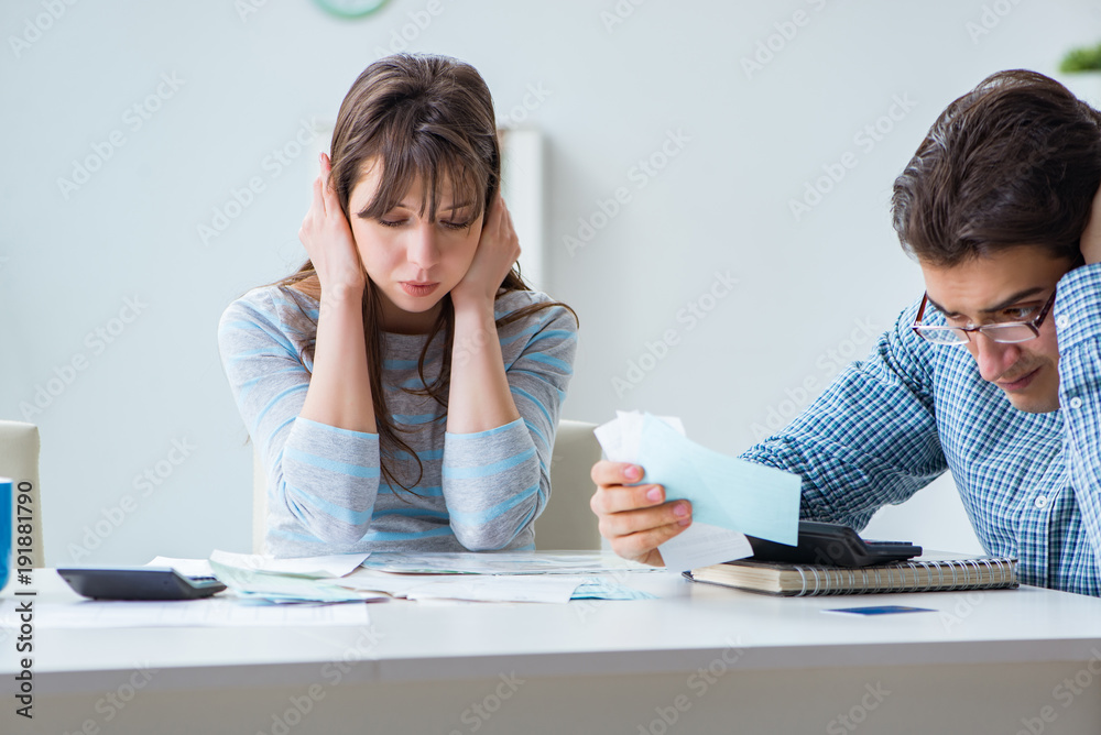 Young couple looking at family finance papers Young couple looking at family finance papers
