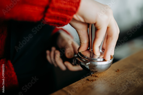 Barista is preparing making coffee with temper in hands