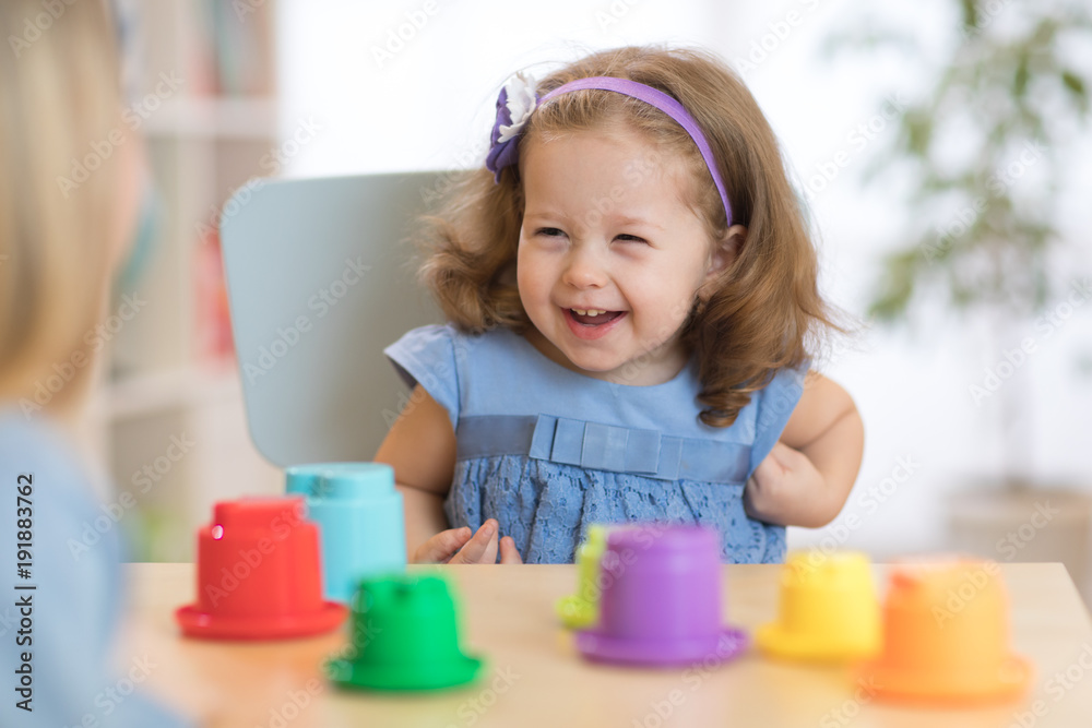 2 year-old child playing with educational cup toys at home. 2 year-old child playing with educational cup toys at home.