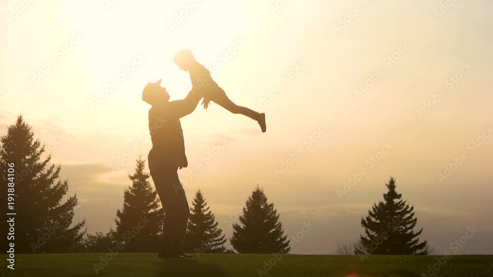 Father playing with daughter in Park, slow motion. Side view, daddy and daughter in the park in the evening. Father playing with daughter in Park, slow motion. Side view, daddy and daughter in the park in the evening.