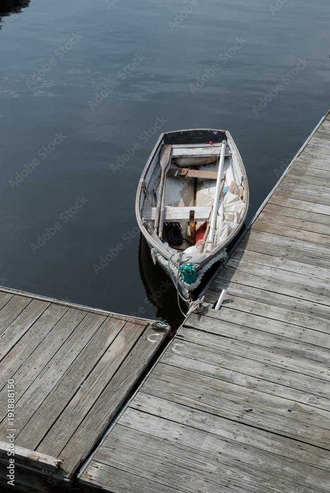 Old timers rowboat tied up to a weathered dock on the Maine Coast