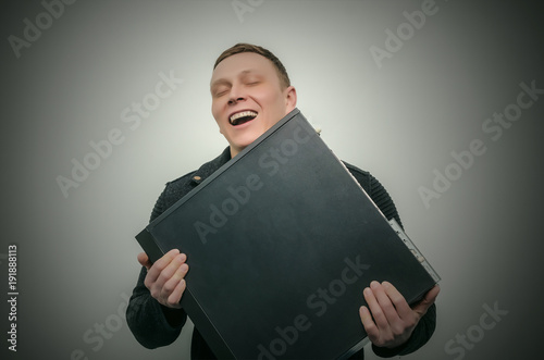 Happy computer tecnician man hugs a computer isolated on dark background. Gamer man love his computer. Computer dependent concept. When buy a new PC. photo