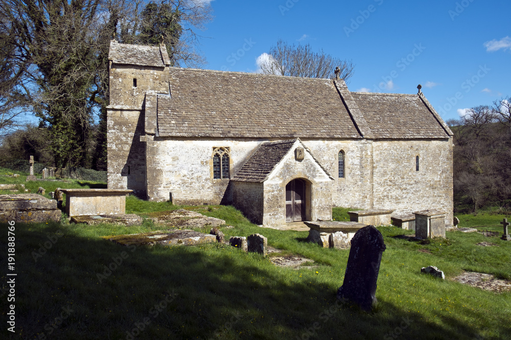 Spring sunshine on the picturesque old church at Duntisbourne Rouse in the Cotswolds, Gloucestershire, UK
