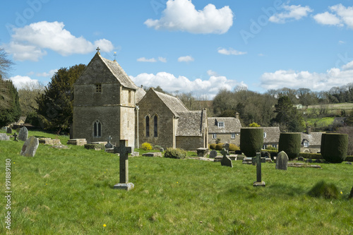 Spring sunshine on the picturesque old church at Duntisbourne Abbots in the Cotswolds, Gloucestershire, UK photo