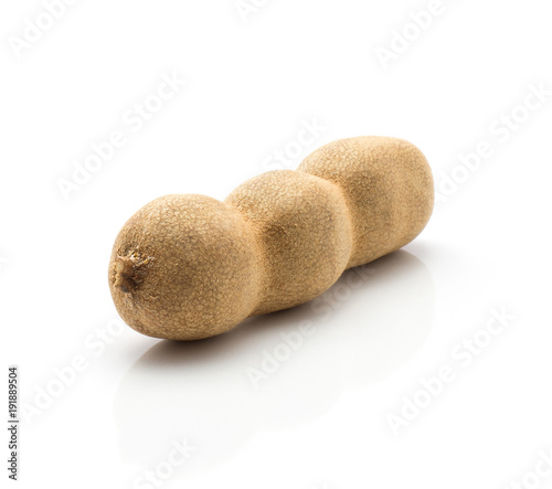 One tamarind Indian date in a brown brittle shell isolated on white background.